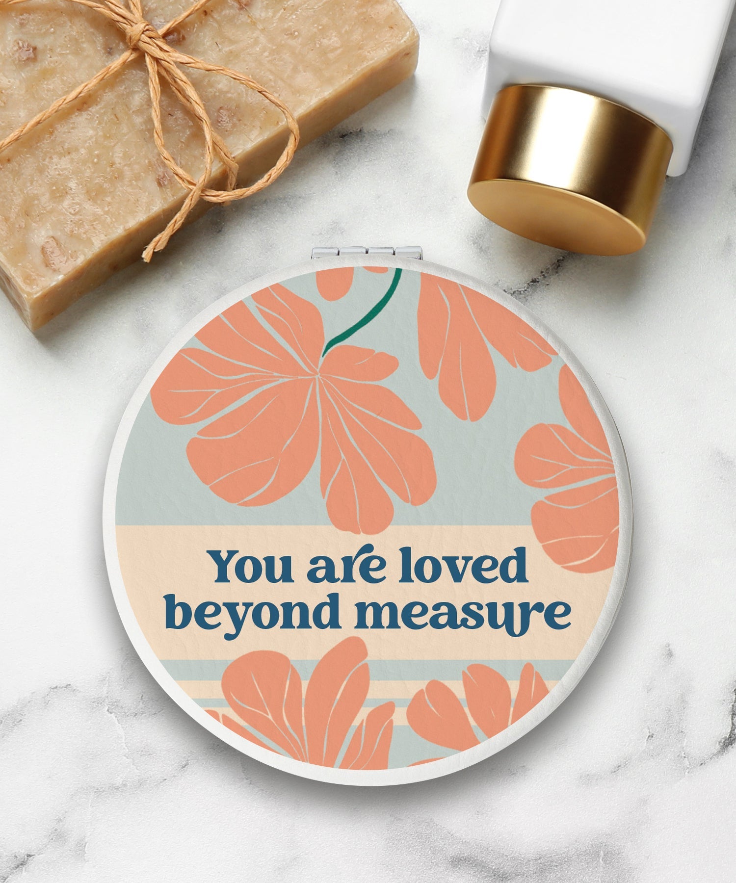 Round compact mirror with a leatherette cover, full-color “You Are Loved” design, 1X and 2X mirrors inside, and magnetic closure.