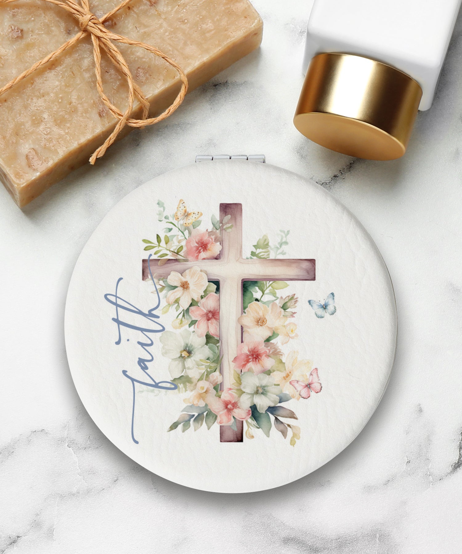 Round compact mirror with a leatherette cover, full-color “Faith” design, 1X and 2X mirrors inside, and magnetic closure.