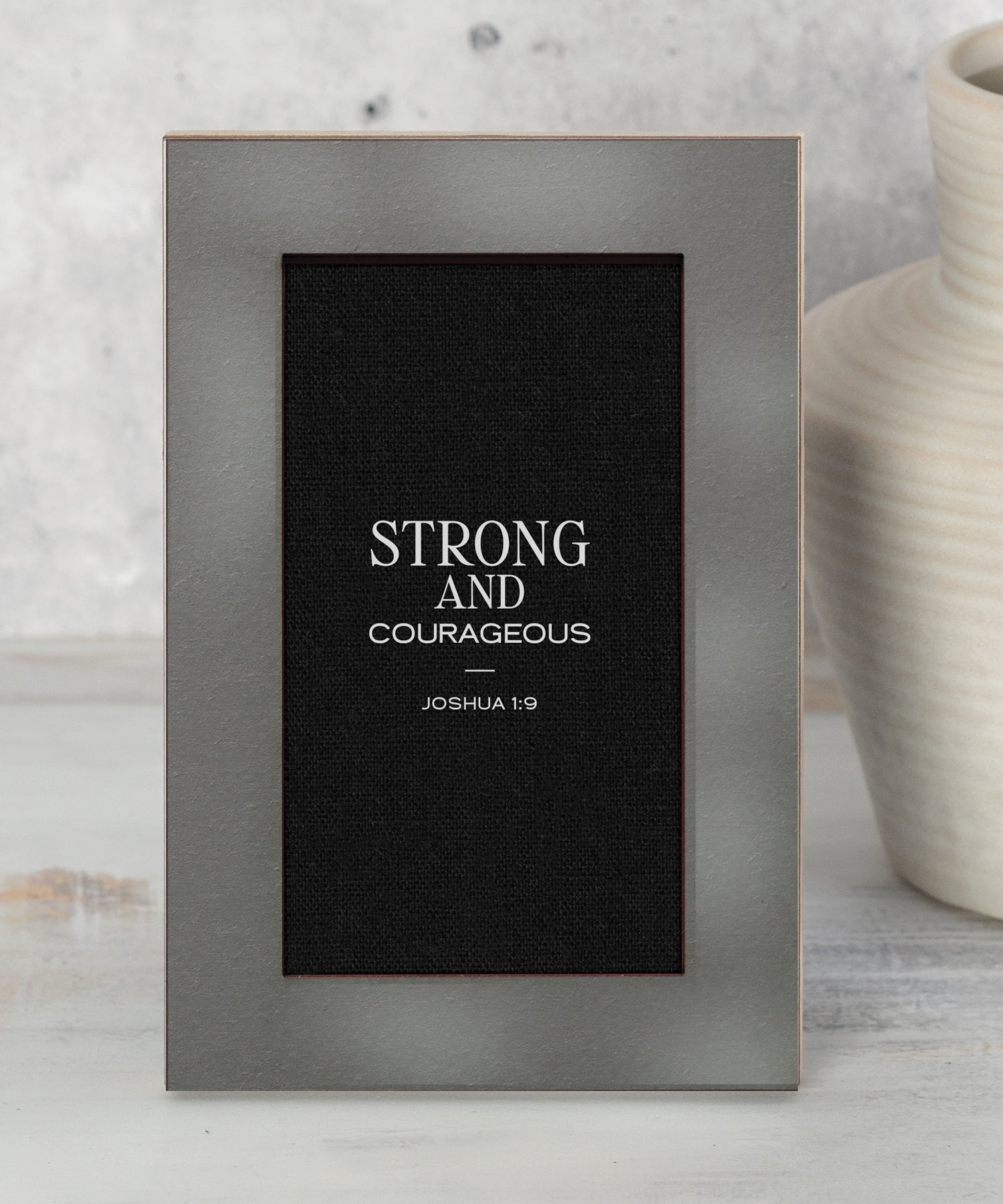 Modern Grace Strong and Courageous 4x6 MDF tabletop plaque featuring Joshua 1:9 with charcoal layered frame and black linen-inspired background