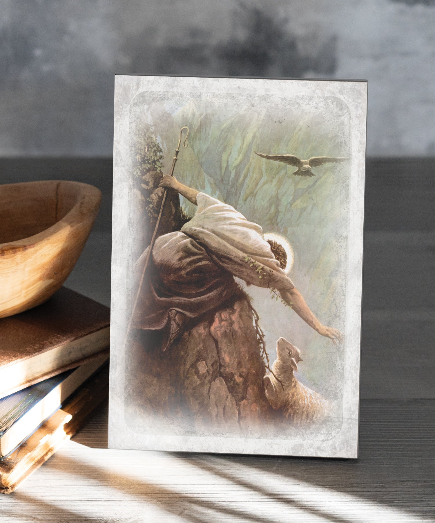 The Lost Sheep 6x9 MDF Plaque has natural edges, muted tones, and inspirational imagery reflecting our faith in God. The plaque features full-color printing and a metal hanger and easel back.