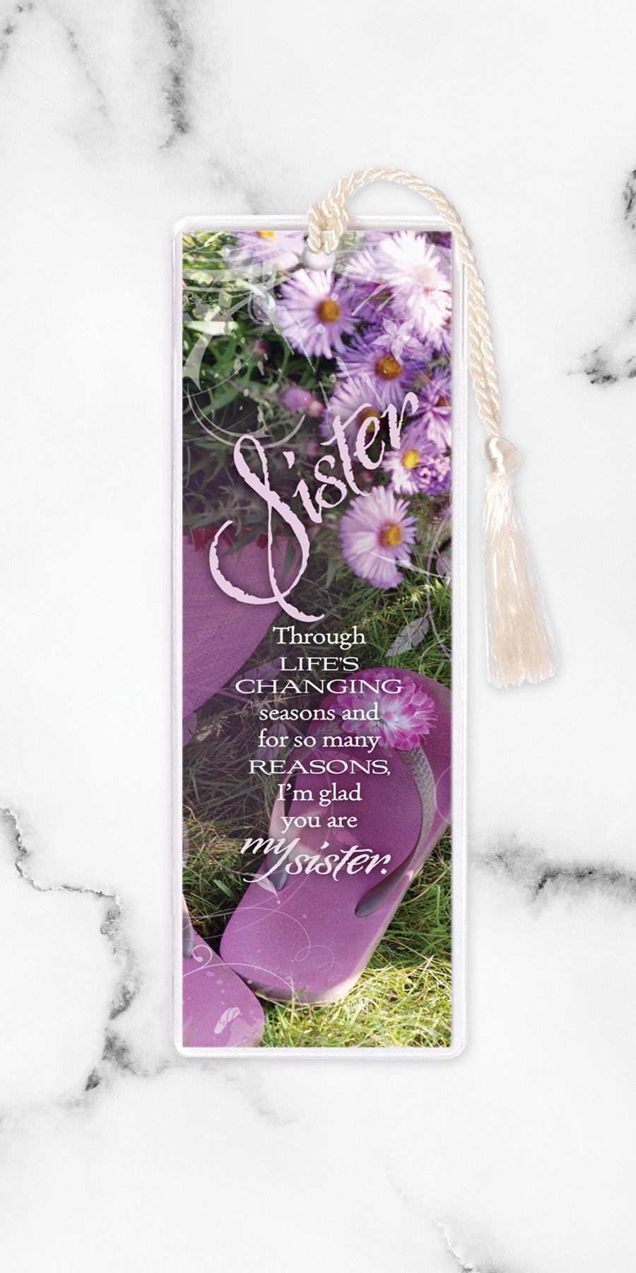 An elegant double-sided bookmark, Sister, is protected by a clear vinyl sleeve and finished with a tassel.