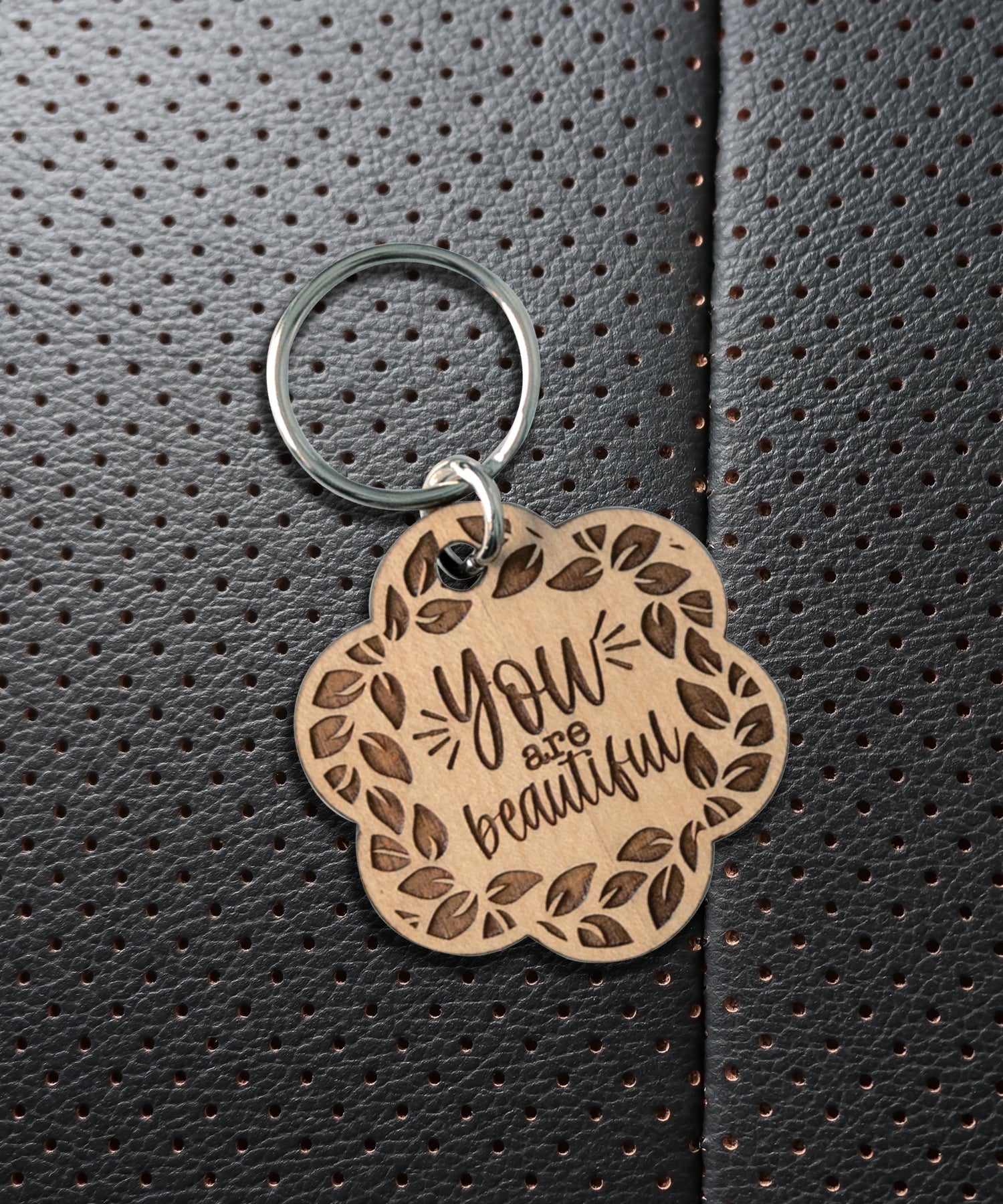 Natural maple wood keychains have a laser-cut shape and laser-engraved You Are Beautiful inspirational verse.