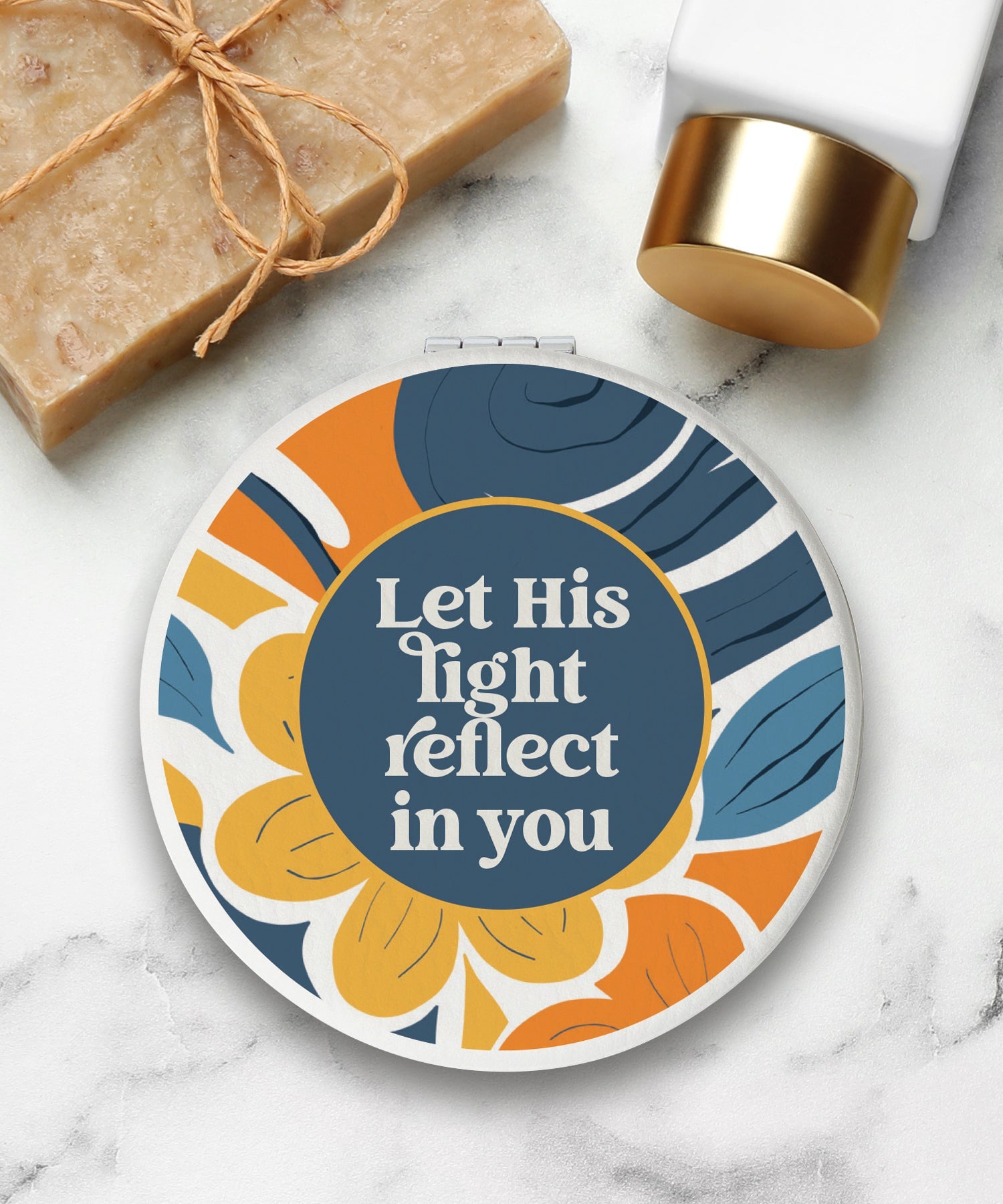 Round compact mirror with a leatherette cover, full-color “Let His Light Reflect in You” design, 1X and 2X mirrors inside, and magnetic closure.