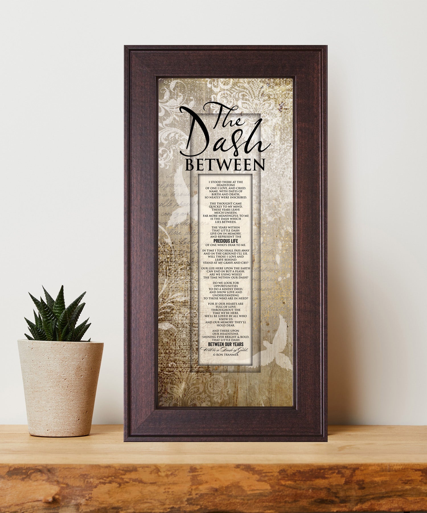 The Dash Between Framed Art with the inspirational poem is displayed prominently. The design includes elegant typography on a textured background, framed in a classic wood frame with a sophisticated finish.