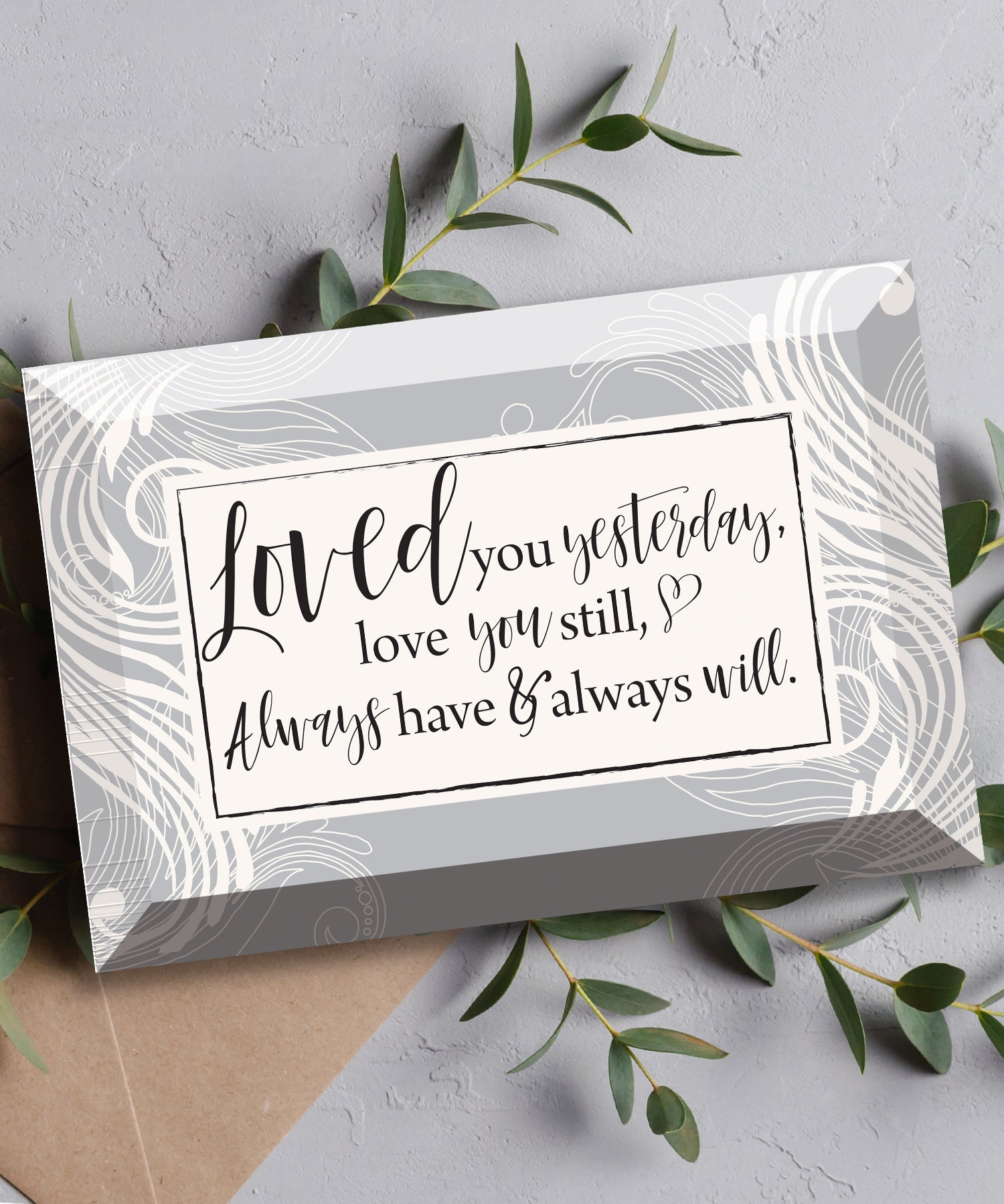 Loved You Yesterday Glass Plaque, which has smooth beveled edges and a screen-printed design, is perfect for display on a shelf.
