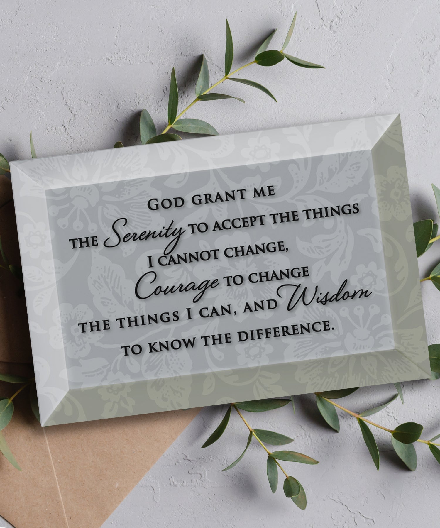 Serenity Prayer Glass Plaque, which has smooth beveled edges and a screen-printed design, is perfect for display on a shelf.