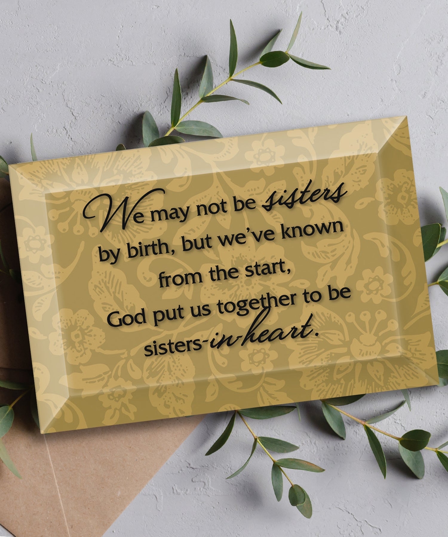 Sisters-in-Heart Glass Plaque, which has smooth beveled edges and a screen-printed design, is perfect for display on a shelf.