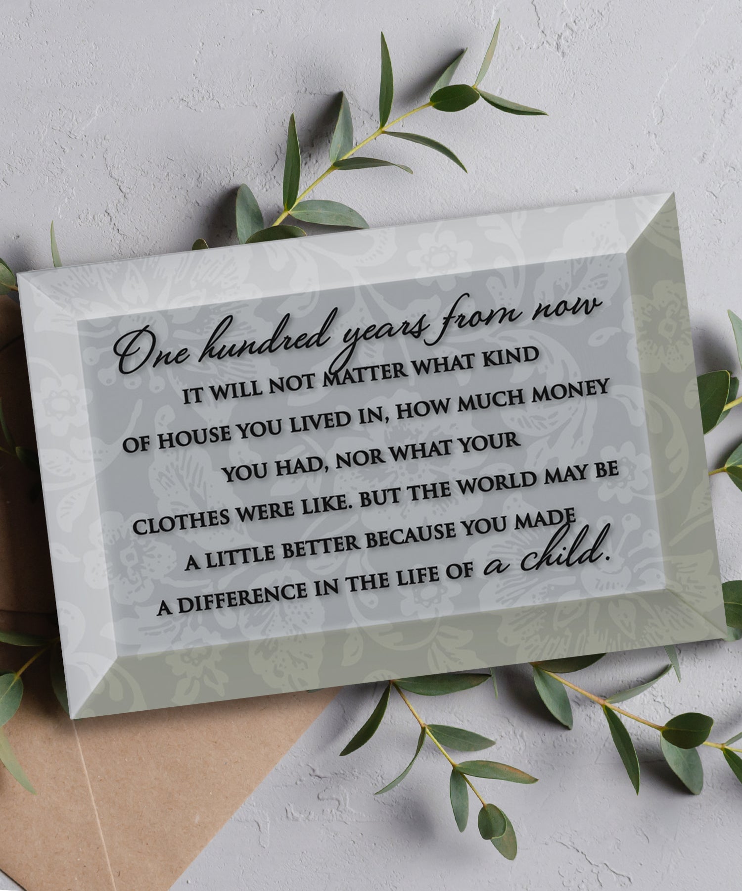 One Hundred Years Glass Plaque, which has smooth beveled edges and a screen-printed design, is perfect for display on a shelf.