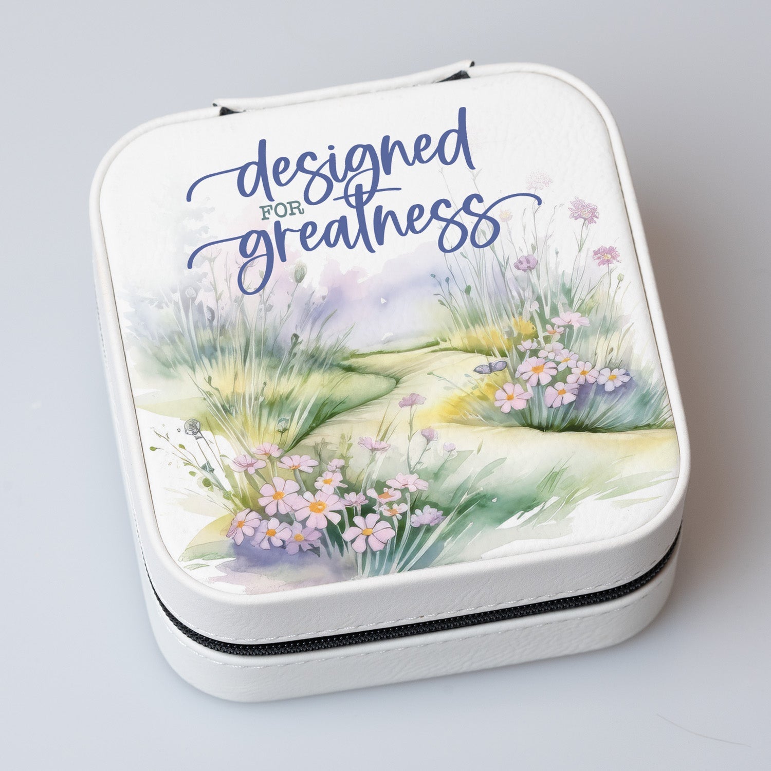 Designed for Greatness Travel Jewelry Case in off-white leatherette with a zipper closure and plush black velvet interior.