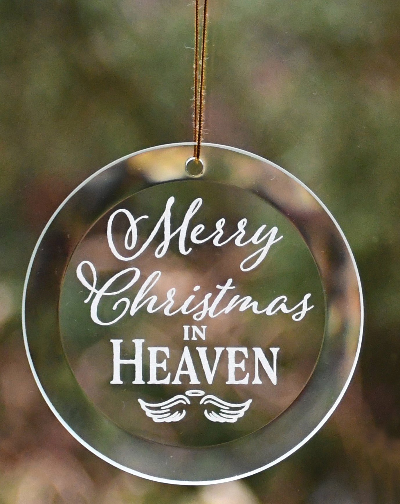 Merry Christmas in Heaven glass ornament with laser-etched design, suspended by a gold-colored string